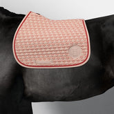 Sportliche Harcour Jump Schabracke Karembar Jump Shell Grapefruit auf schwarzem Rappen. Der helle Beigeton Shell leuchtet auf dem schwarzen Kurzhaar. Perfekte Lage unter dem Springsattel beim Ausritt oder Training. Mit Waffelstruktur-Innenfutter für schnelle Trocknung.