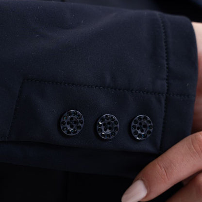 Detailbild der drei Knöpfe am rechten Ärmel des Harcour Turnierjackets Oria in Aubergine. Die eleganten Knöpfe sind, genau wie der Knopfverschluss, mit gleichfarbigen, dunkelroten Kristallsteinen besetzt und glitzern bei jeder Bewegung im Sonnenlicht. Diese edlen Ton-in-Ton Strasssteine runden das besondere Design des Reitsakkos perfekt ab. Ein luxuriöses Detail für modische Turnierreiterinnen, die auf der Suche nach außergewöhnlicher und hochwertiger Turnierbekleidung mit Strass sind.
