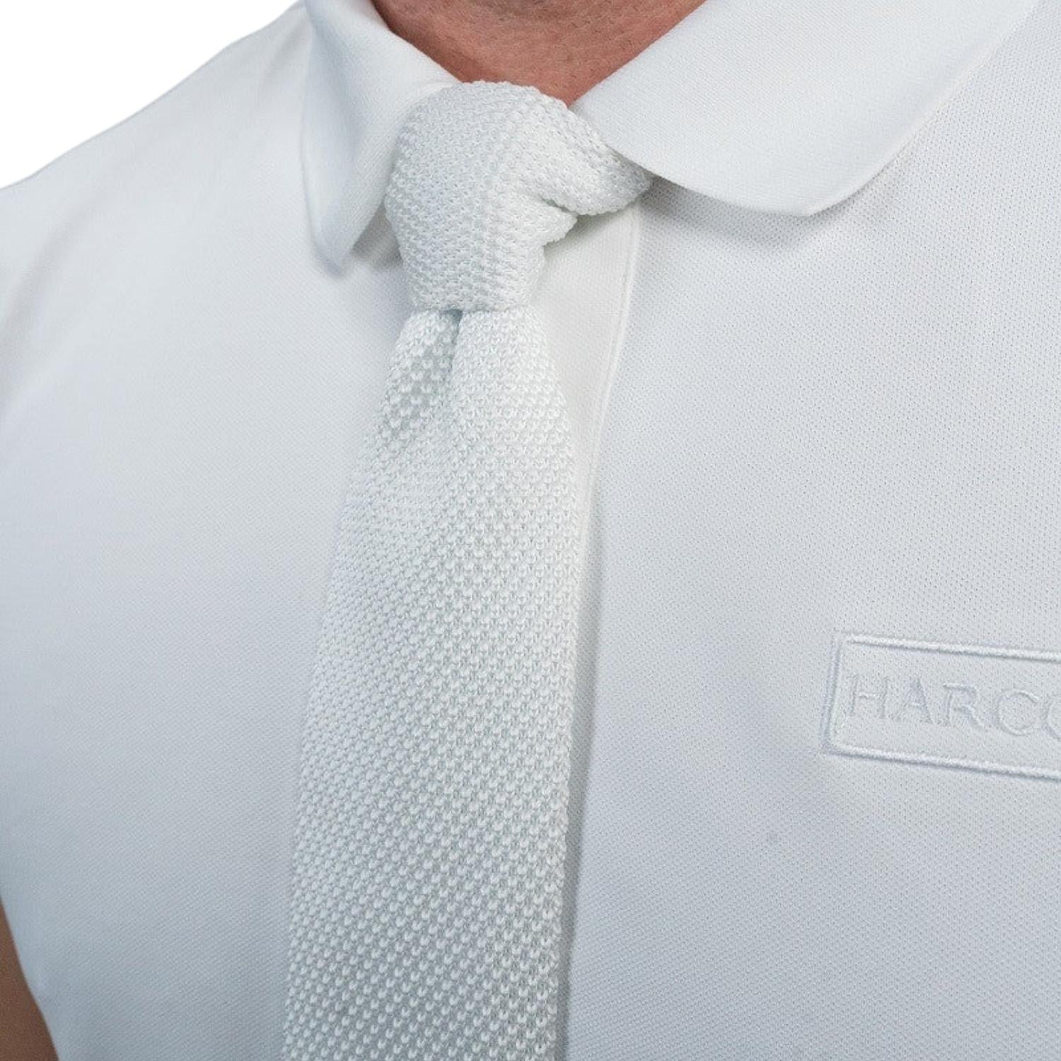 Detailaufnahme der weißen Harcour Herren Turnierkrawatte Corbi in hochauflösendem Waffelpique. Unverzichtbares Accessoire für korrekte Turnierkleidung im Reitsport. Die edle Struktur des Materials sorgt für eine exzellente Optik unter dem Reitjackett.
