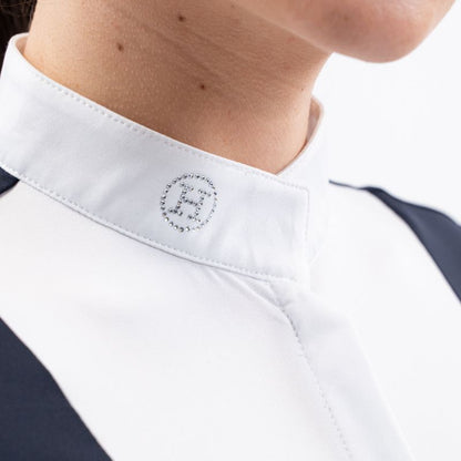 Detailansicht des Stehkragens am Harcour Turniershirt Shine Navy mit dem funkelnden Kristall-Glitzerlogo auf der rechten Halsseite, der elegant unter einem Turnierjacket oder Reitfrack hervorsteht und die innovative Funktion des Magnetverschlusses für ein einfaches Schließen andeutet.