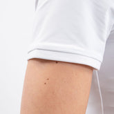 Eine Detailaufnahme des Harcour-Turniershirts „Shine in White zeigt den Ärmel des Kurzarmshirts für Damen. Ideal bei höheren Temperaturen im Sommer während dem Reiten, und in den Turnierprüfungen unter einem Turnierjackettoder Dressurfrack. Dies macht das Shirt zu einem sportlich-eleganten Oberteil für Damen und Turnierreiterinnen.