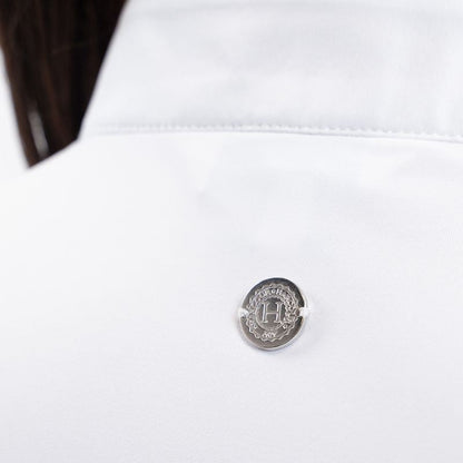Die Rückansicht des Harcour Turniershirts Shine White mit dem dezenten, runden, silbernen Logo auf dem elastischen Stretchmaterial für optimale Bewegungsfreiheit. Der darüber liegende Stehkragen in Weiß ragt aus dem Turnierjacket heraus und macht ein Plastron überflüssig. 