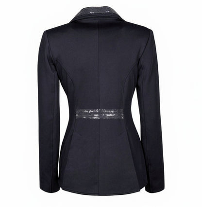 Die Rückansicht des Harry’s Horse Turnierjackets Montpellier im modernen Kurzfrack-Stil präsentiert die elegante Schnittführung für anspruchsvolle Dressurreiterinnen. Im Vergleich zum klassischen Dressurfrack enden die angedeuteten Dressurschöße knapp über dem Sattel, was eine betonte, feminine Taille akzentuiert. Zwei Gehschlitze sorgen für optimale Bewegungsfreiheit. Ein mit dunkelblauen Pailletten betontes, angedeutetes Gürtelband sowie der durchgängig mit Glitzerdetails versehene Kragensteg.