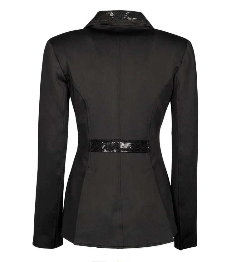 Die Rückansicht des Harry’s Horse Turnierjackets Montpellier im modernen Kurzfrack-Stil präsentiert die elegante Schnittführung für anspruchsvolle Dressurreiterinnen. Im Vergleich zum klassischen Dressurfrack enden die angedeuteten Dressurschöße knapp über dem Sattel, was eine betonte, feminine Taille akzentuiert. Zwei Gehschlitze sorgen für optimale Bewegungsfreiheit. Ein mit schwarzen Pailletten betontes, angedeutetes Gürtelband sowie der durchgängig mit Glitzerdetails am Kragensteg.