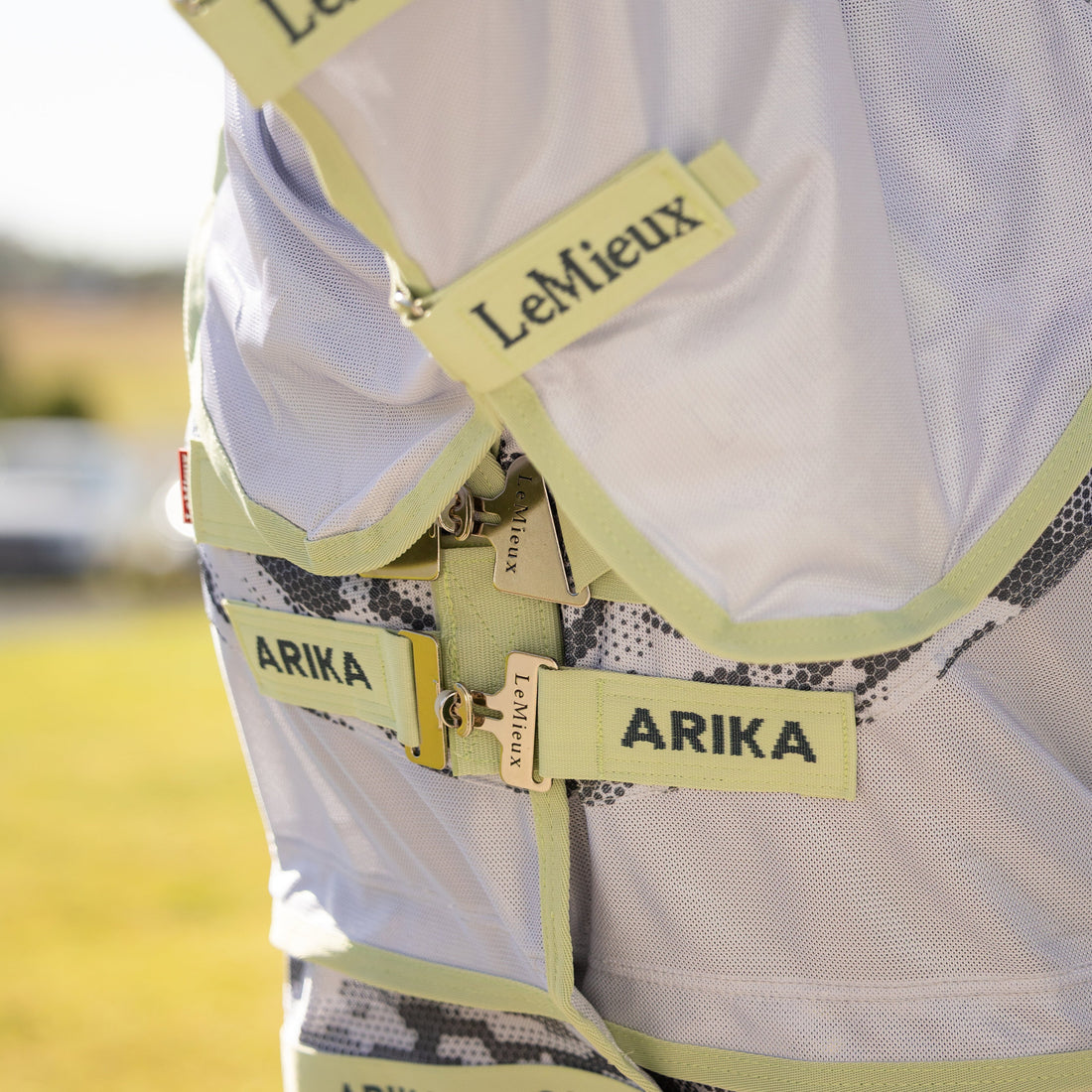 Die Nahaufnahme zeigt den innovativen Arika-Brustverschluss der LeMieux Fliegendecke mit seinen um 45 Grad abgewinkelten T-Stegen in der Kontrastfarbe Macaron, die für eine gleichmäßige Druckverteilung sorgen, sowie die stabilen Klettverschlüsse des passenden, abnehmbaren Halsteils.
