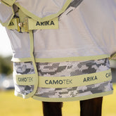 Die Nahaufnahme zeigt den patentierten, zweiteiligen Saum der LeMieux Arika Camo-Tek Fliegendecke im Camouflage-Muster mit hellgrünen Macaron-Abschlüssen und Logo-Aufdruck, was nicht nur absolute Bewegungsfreiheit ermöglicht, sondern auch das Bremsen durch den Tarneffekt die Umrisse des Pferdes nicht erkennen und auf ihm landen können.