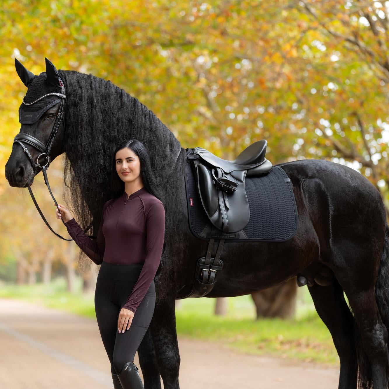 Schwarze LeMieux Essence Dressurschabracke am Friesen: Die Sattelunterlage zeigt die ideale Länge für Dressursättel mit langem Sattelblatt. Das Softshell-Material der Essence Black Edition sorgt für Formstabilität und Belüftung im Training. Die anatomische Schnittführung garantiert eine ruhige Sattellage und verhindert das Hineinziehen in die Kammer.