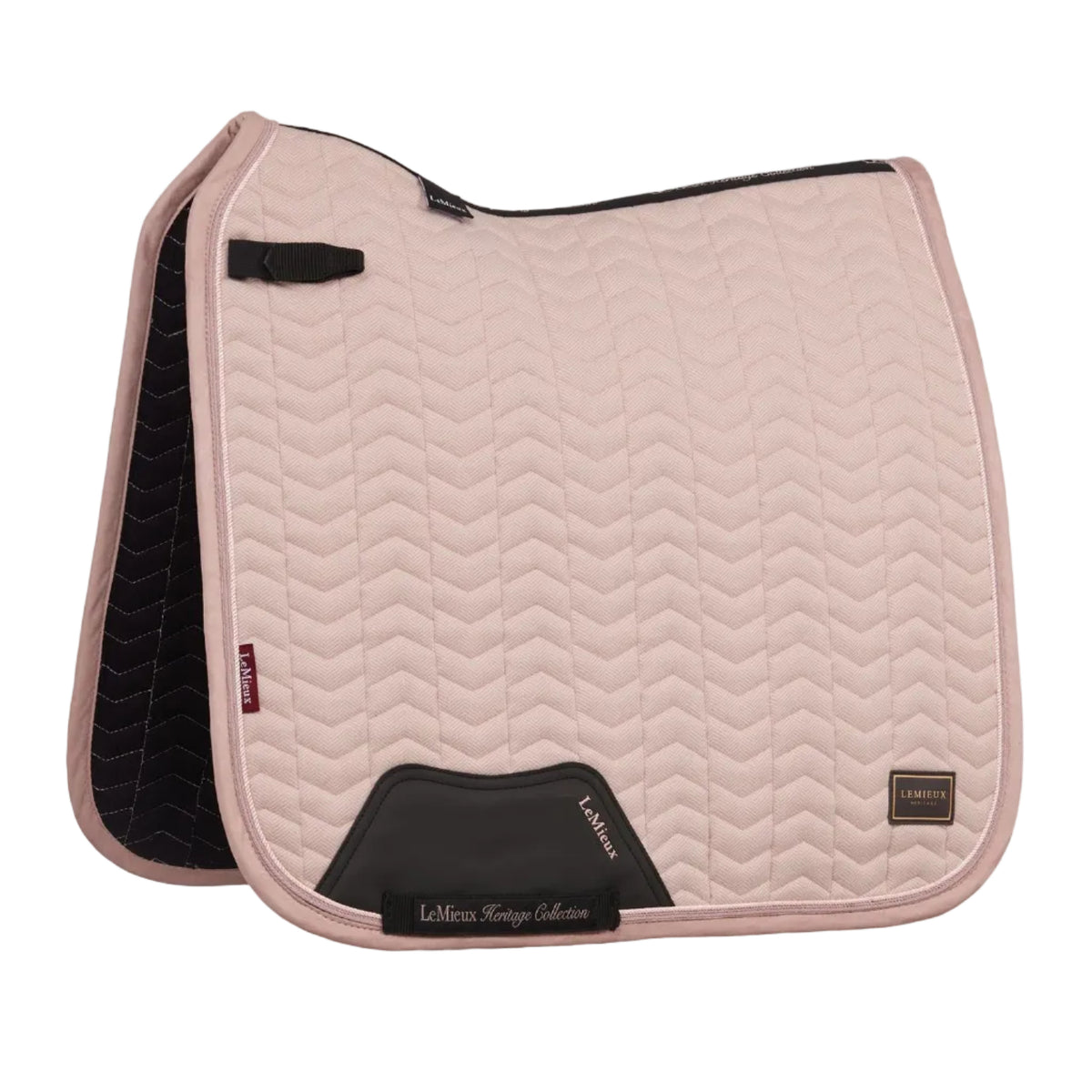 Gesamtansicht der LeMieux Heritage Dressurschabracke Herringbone im pastellfarbenen Ton Wild Rose (Altrosa) mit feiner Chevron-Steppung. Die Aufnahme zeigt den anatomischen Schwanenhals-Schnitt für hohe Widerristfreiheit, die elastische D-Ring-Befestigung sowie den verstärkten PU-Leder-Gurtschutz mit LeMieux-Heritage-Stickung.