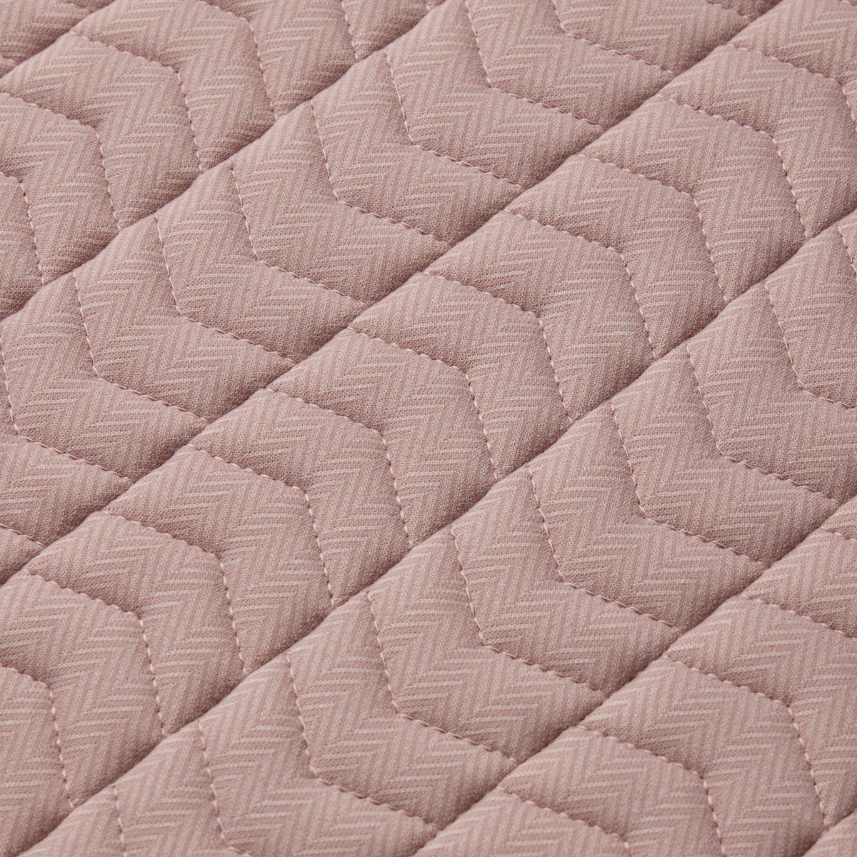 Detailaufnahme der LeMieux Heritage Dressurschabracke im Farbton Wild Rose (Altrosa) mit Fokus auf die feine Webstruktur. Das Bild zeigt das traditionelle Fischgrätmuster (Herringbone) in Kombination mit der eleganten Chevron-Steppung, die für Formstabilität und eine gleichmäßige Druckverteilung auf dem Pferderücken sorgt.