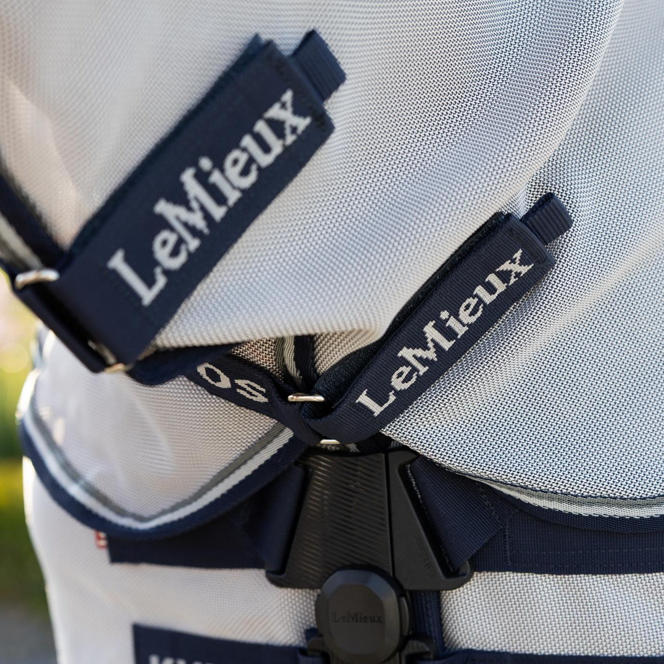 Detailansicht der robusten Klettverschlüsse am abnehmbaren Halsteil der grauen LeMieux Kudos Gladiator Fliegendecke, versehen mit dem hochwertigen originalen LeMieux Marken-Branding.