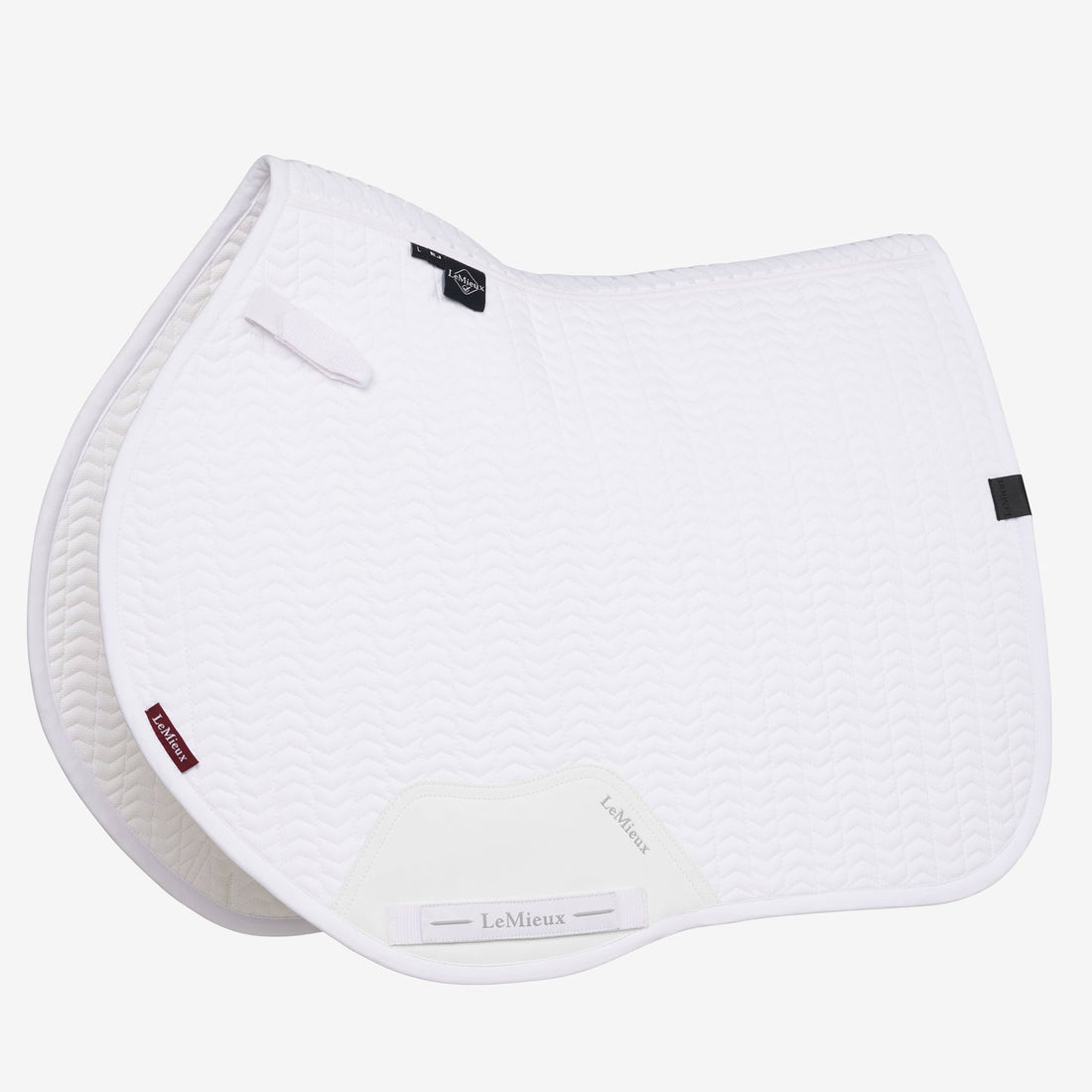 Die LeMieux Essence Eurojump Springschabracke in Weiß zeigt das zeitlose Chevron-Muster in der professionellen Turnierausführung. Der Eurojump-Schnitt mit nach vorne ausgestellter Form bietet absolute Schulterfreiheit für das Pferd und unterstützt den optimalen Springsitz bei verkürzter Bügellänge. Die Oberlinie mit Schwanenhals, 3D-Carbon-Mesh und Self-Cool-Futter garantiert maximale Luftzirkulation und aktive Kühlung bei sommerlichen Turnieren.