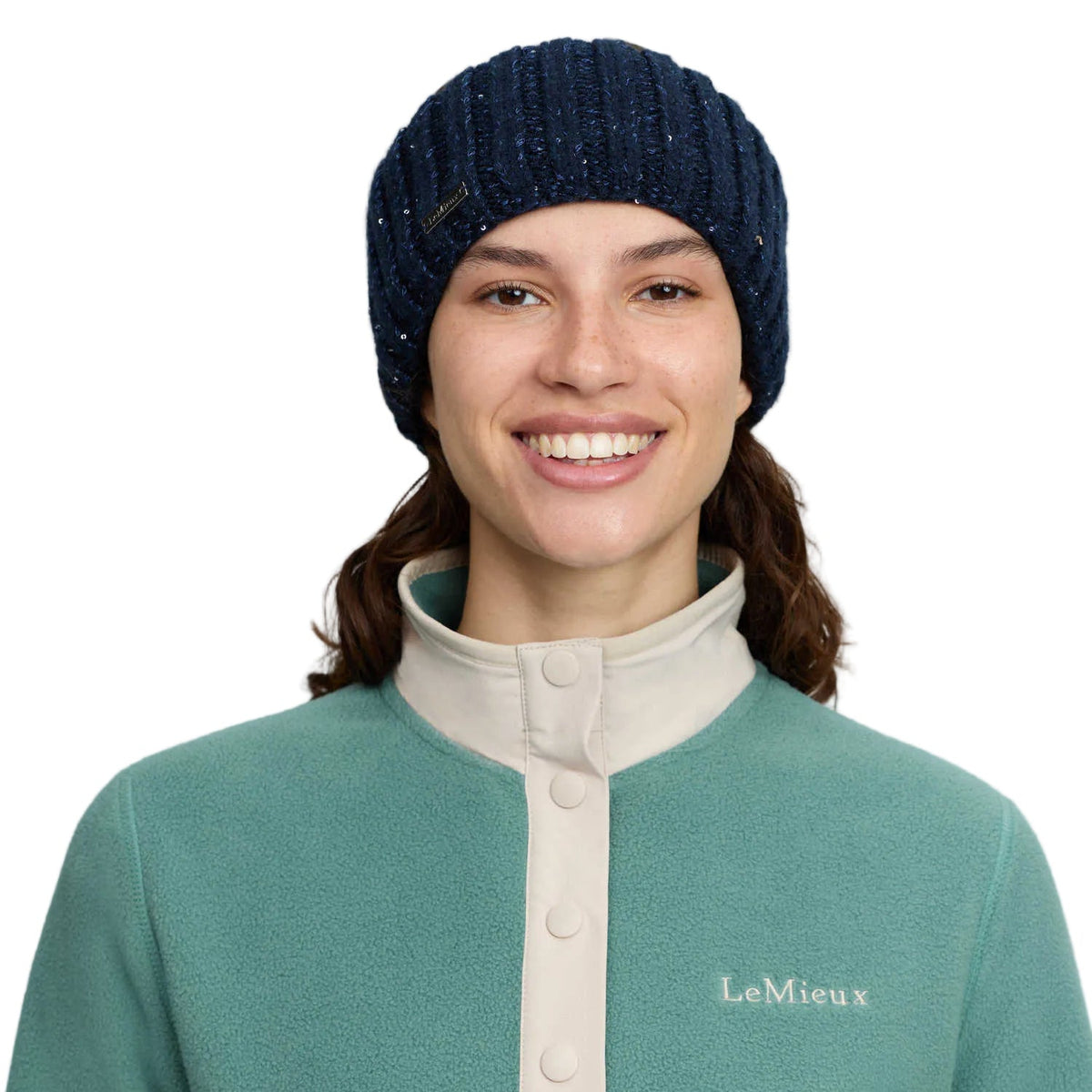 Dunkelblaues LeMieux Damen-Stirnband Bernie mit dezentem Paillettengarn und silbernem Metall-Logo, frontal getragen von einer Reiterin als wärmendes Winteraccessoire und modischer Ohrenwärmer für Reitoutfits im Reitsport und Alltag.
