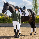 Hochtechnische Performance im Dressurviereck: Die weiße LeMieux Essence Turnierschabracke kombiniert eine klassische Turnier-Optik mit extrem schweißabsorbierenden Effekten. Während die Außenseite traditionelle Eleganz ausstrahlt, sorgt das kühlende Self-Cool-Gewebe bei sommerlichen Turniertemperaturen für eine aktive Temperaturregulierung. Diese Verbindung aus technischem High-Tech-Stoff und zeitlosem Design garantiert ein trockenes Gefühl unter dem Sattel.