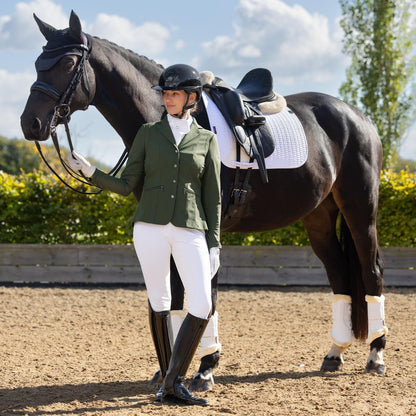 Hochtechnische Performance im Dressurviereck: Die weiße LeMieux Essence Turnierschabracke kombiniert eine klassische Turnier-Optik mit extrem schweißabsorbierenden Effekten. Während die Außenseite traditionelle Eleganz ausstrahlt, sorgt das kühlende Self-Cool-Gewebe bei sommerlichen Turniertemperaturen für eine aktive Temperaturregulierung. Diese Verbindung aus technischem High-Tech-Stoff und zeitlosem Design garantiert ein trockenes Gefühl unter dem Sattel.