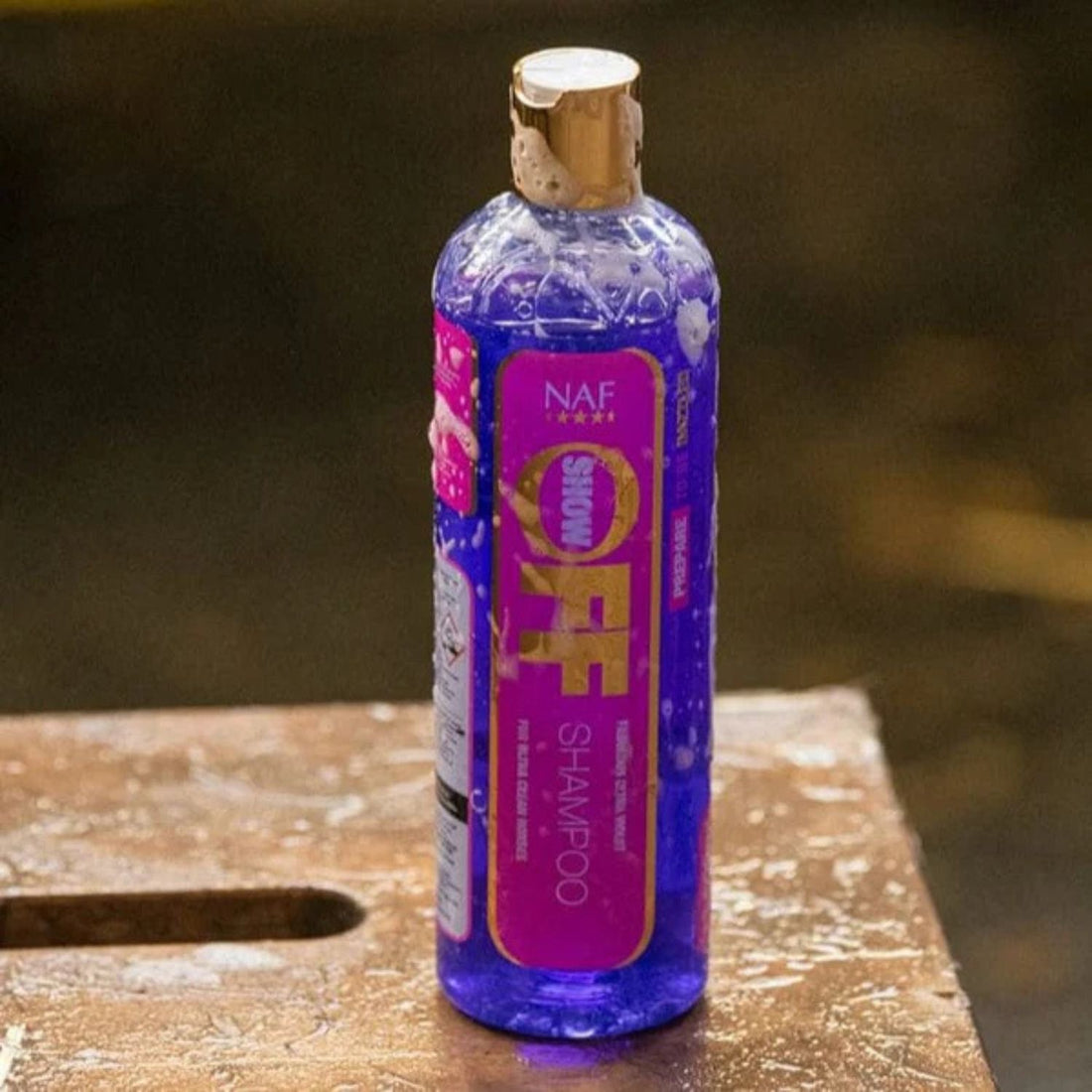 Anwendung des NAF Show Off Shampoos beim Waschen eines Pferdes – stark reinigendes Pferdeshampoo für Glanz, sauberes Fell und sanfte Pflege. Darf in der Pferdepflege und in der Putzbox nicht fehlen. Auffälliges Produktetikett in Pink und dunkel-violettes Shampoo sind ein Hingucker. 
