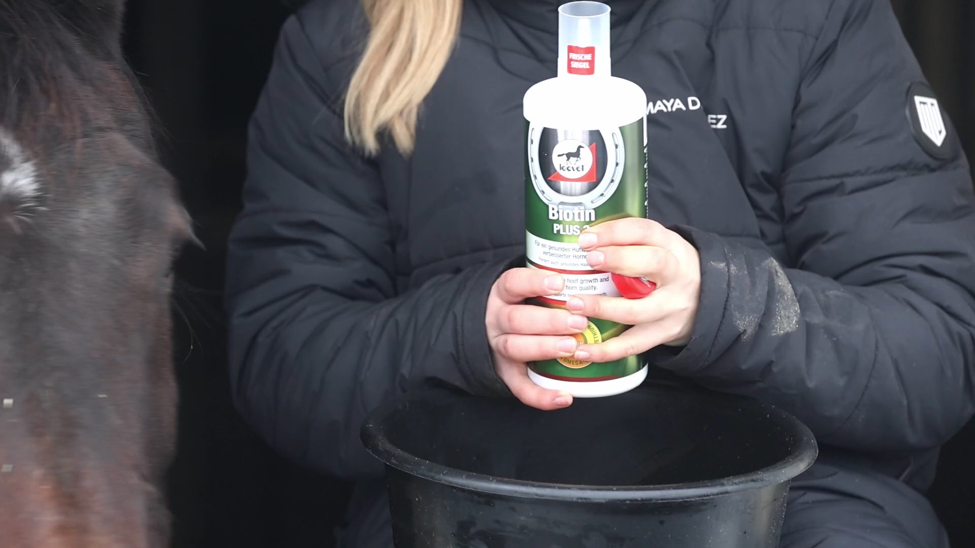 Anwendungsvideo leovet Biotin Plus 3: Einfache Dosierung des flüssigen Ergänzungsfuttermittels für Pferde. Die Reiterin zeigt das exakte Abmessen von 20 ml in der 1-Liter-Dosierflasche und die hohe Futterakzeptanz beim Mischen ins Kraftfutter. Perfekte Nährstoffkombination mit Zink, Methionin und Omega 3 zur Unterstützung von Hufwachstum, Hornqualität und dem Fell.