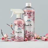 Stübben Brush On Cherry Blossom als 500 ml Sprühflasche und 1 Liter Nachfüllflasche im Stillleben mit Kirschblüten. Glanzspray für Mähne und Schweif zum Nachfüllen der Sprühflasche.