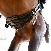 Detailansicht des schwarzen Stübben Equi-Soft Polsters aus Vachetteleder am Pferd von unten fotografiert. Die elastischen Bänder des Equi-Soft Sattelgurtes dehnen sich dynamisch aus, während die ergonomische Schmetterlingsform des Equi-Soft-Polsters präzise am Brustbein aufliegt, um Druckstellen zu verhindern.