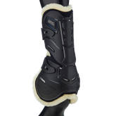 Stübben Hybrid Springgamasche (Hinteransicht) mit Fokus auf den Sehnen-Schlagschutz, Belüftungsöffnungen und weichen Fleece-Rand am Pferdebein. Das innovative Design mit sicherem Pin-Schnellverschluss unterstützt die Biomechanik und lässt sich als universeller schwarzer Beinschutz mit jedem Reitoutfit kombinieren.