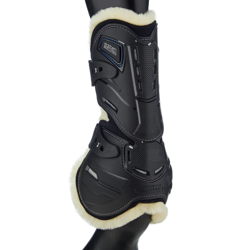Stübben Hybrid Springgamasche (Hinteransicht) mit Fokus auf den Sehnen-Schlagschutz, Belüftungsöffnungen und weichen Fleece-Rand am Pferdebein. Das innovative Design mit sicherem Pin-Schnellverschluss unterstützt die Biomechanik und lässt sich als universeller schwarzer Beinschutz mit jedem Reitoutfit kombinieren.
