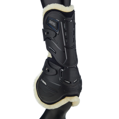 Stübben Hybrid Springgamasche (Hinteransicht) mit Fokus auf den Sehnen-Schlagschutz, Belüftungsöffnungen und weichen Fleece-Rand am Pferdebein. Das innovative Design mit sicherem Pin-Schnellverschluss unterstützt die Biomechanik und lässt sich als universeller schwarzer Beinschutz mit jedem Reitoutfit kombinieren.