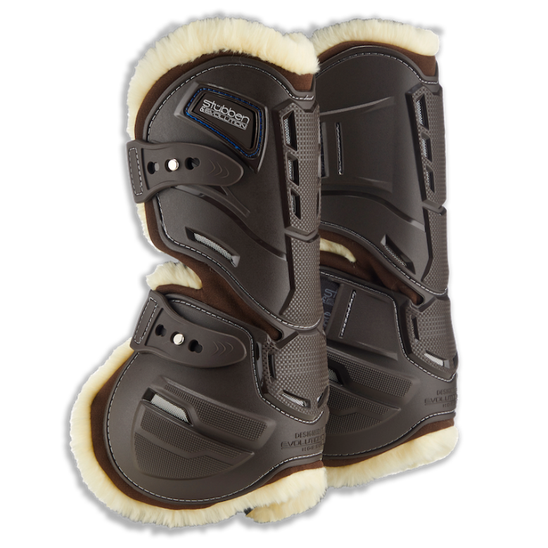 Paar Stübben Hybrid Springgamaschen der Evolution Serie in Braun für die Vorderbeine mit kontrastierendem hellem Fleece-Futter. Das Bild zeigt das innovative seitliche Cut-Out-System, das natürliche Bewegungsabläufe wie Stauchen und Dehnen am Pferdebein ermöglicht. Sichtbar sind die strategischen Belüftungsöffnungen gegen Hitzestau sowie die elastischen Schnellverschlüsse. Das beigefarbene Fleece-Fell für empfindliche Pferde bildet einen eleganten Kontrast zur braunen Hartschale.