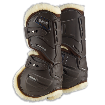 Paar Stübben Hybrid Springgamaschen der Evolution Serie in Braun für die Vorderbeine mit kontrastierendem hellem Fleece-Futter. Das Bild zeigt das innovative seitliche Cut-Out-System, das natürliche Bewegungsabläufe wie Stauchen und Dehnen am Pferdebein ermöglicht. Sichtbar sind die strategischen Belüftungsöffnungen gegen Hitzestau sowie die elastischen Schnellverschlüsse. Das beigefarbene Fleece-Fell für empfindliche Pferde bildet einen eleganten Kontrast zur braunen Hartschale.