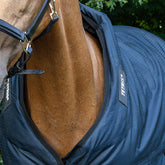 ie Frontalansicht der Trust Tetris Outdoordecke verdeutlicht die perfekte Passform am geschlossenen Halsbereich, wobei das Volumen der innenliegenden Polsterblöcke des Tetris-Systems deutlich erkennbar ist, um eine konsequente Last- und Druckverteilung des Decken-Eigengewichts zu garantieren und Haarbruch sowie Scheuerstellen selbst in intensiven Bewegungsabläufen pferdefreundlich zu verhindern.