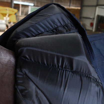 Diese Nahaufnahme der aufgeschlagenen Trust Equestrian Tetris Outdoordecke zeigt das revolutionäre Tetris-System mit seinen weichen Polsterblöcken, die den Widerrist rechts und links passgenau einrahmen und einen schützenden Tunnel bilden, um maximalen Freiraum zu garantieren und gefährliche Druckstellen sowie Haarbruch selbst bei Pferden mit extrem hohem Widerrist oder empfindlicher Haut konsequent zu verhindern.