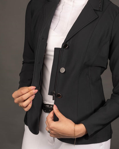 Ein detaillierter Blick auf das geöffnete Turniersakko Onyx demonstriert die praktische Funktionsweise des verdeckten Reißverschlusses unter der klassischen Knopfleiste für einen sicheren Halt beim Reiten.