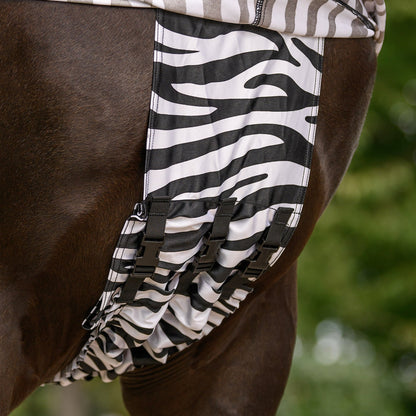 Detailbild der hochgezogenen Waldhausen Ekzemerdecke Zebra Premium im Brustbereich mit Blick auf die Längsfixierung der Bauchnahtabdeckung. Zwischen den Vorderbeinen wird die Decke sicher mit 3 Klickverschlüssen fixiert, sodass die empfindliche Bauchnaht fast komplett bedeckt ist und Kriebelmücken kaum noch Landemöglichkeiten bietet. Dank dieser optimalen Anpassungsmöglichkeiten entsteht ein umfangreicher mechanischer Fliegenschutz für Ponys und Pferde.