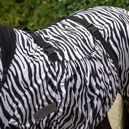 Detailansicht der Waldhausen Ekzemerdecke Zebra Premium, die den sehr breiten Bauchlatz unter dem Pferd zeigt. Dieser deckt die empfindliche Bauchnaht großflächig ab und schützt mechanisch vor Kriebelmücken, Bremsen und anderen Insekten. Durch das Verstellen der Gurte mit ihren praktischen Klickverschlüssen lässt sich dieser umfangreiche mechanische Fliegenschutz individuell anpassen und sichert den perfekten, körpernahen Sitz für Ponys und Pferde.