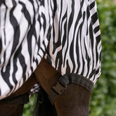 Detailbild der Waldhausen Ekzemerdecke Zebra Premium, das die elastischen Beingurte mit Klickverschlüssen zeigt. Diese verhindern ein Verrutschen der Decke, damit der mechanische Fliegenschutz erhalten bleibt und keine Körperteile plötzlich freiliegen oder für Insekten und Kriebelmücken zugänglich werden. Gleichzeitig bieten die Gurte volle Bewegungsfreiheit, sodass sich dein Pony oder Pferd auf der Wiese und dem Paddock völlig frei bewegen kann.