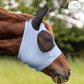 Seitenansicht eines Fuchs auf der Weide mit der Waldhausen Fliegenmaske Puck inPastellblau. Ein UV-Protection-Logo am oberen Bildrand signalisiert den wichtigen Sonnenschutz für empfindliche Pferde. Optisch unauffällig schmiegt sich das leichte Material nah an den Pferdekopf, der Reißverschluss am Kehlbereich ist erahnbar. Das fast durchsichtige, gewölbte Netz steht weit ab und bietet viel Augenfreiheit. Diese helle Weidemaske dient als mechanischer Fliegenschutz zur Abwehr von Bremsen und Kriebelmücken.