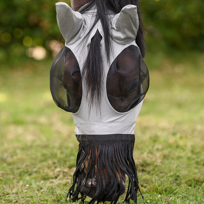 Waldhausen Fliegenmaske Puck mit Nasenfransen auf einem Pferd mit geneigtem Kopf beim Grasen auf der Sommerweide. Die elastische, leichte Fliegenschutzmaske gewährt volle Bewegungsfreiheit für Pony und Pferd. Die langen Nasenfransen hängen über das Pferdemaul, ohne beim Fressen oder Trinken an der Tränke zu stören. Durch den klassischen Schopfdurchlass zwischen den Ohren wird der Pferdeschopf nach außen gezogen, sodass das Langhaar auf dem Bild locker herabhängt und sich nicht unter der Maske staut.