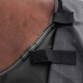 Detailansicht der Klettverschluss-Befestigung für ein separates Halsteil an der Waldhausen-Outdoordecke Arctic 100 g in Schwarz aus 600D Ripstop. Die integrierten Klettverbindungen ermöglichen das einfache Anbringen eines passenden Arctic-Halsteils zum Schutz von Hals und Mähne vor Regen, Wind und Nässe. Das modulare System bietet flexibles Pferdedeckenmanagement für die abgestimmten Temperaturbedingungen von Pferd und Pony im Herbst, Frühjahr und Winter.