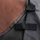 Detailansicht der Klettverschluss-Befestigung für ein separates Halsteil an der Waldhausen-Outdoordecke Arctic 200 g in Schwarz aus 600D Ripstop. Die integrierten Klettverbindungen ermöglichen das einfache Anbringen eines passenden Arctic-Halsteils zum Schutz von Hals und Mähne vor Regen, Wind und Nässe. Das modulare System bietet flexibles Pferdedeckenmanagement für die abgestimmten Temperaturbedingungen von Pferd und Pony im Herbst, Frühjahr und Winter.