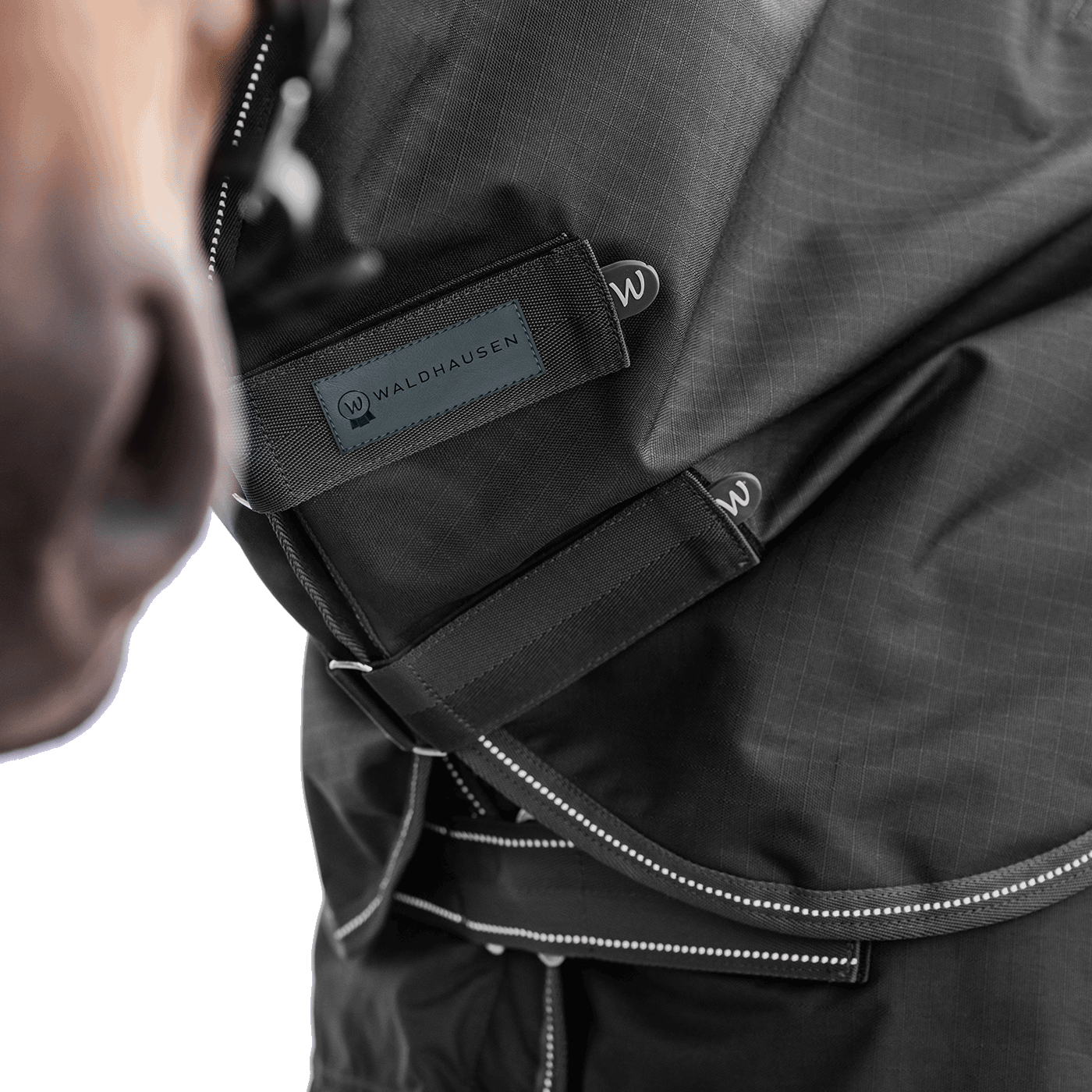 Detailaufnahme des Waldhausen Outdoorhalsteils in Schwarz am Pferdehals. Der Fokus liegt auf den zwei verstellbaren Klettverschlüssen zum einfachen Öffnen, Schließen und präzisen Anpassen der Passform für Pony und Pferd.