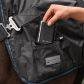 Einsetzen der originalen Waldhausen Powerbank (5000 mAh / 7,4 V) in die integrierte Reißverschlusstasche der Waldhausen TecSupreme Heiz- und Massagedecke am Pferd zur unterbrechungsfreien Stromversorgung der Wellness-Funktionen.