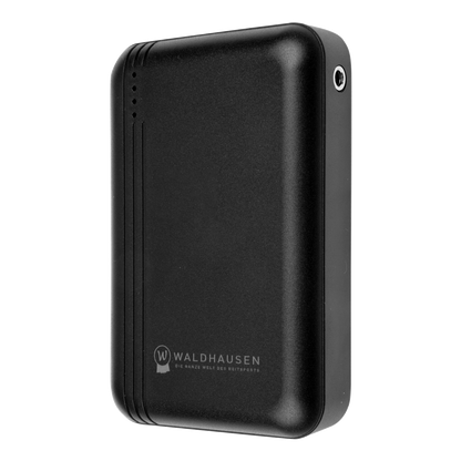 Seitenperspektive der originalen Waldhausen Health + Care TecSupreme Powerbank (5000 mAh / 7,4 V) mit sichtbarem DC-Rundanschluss für das Verbindungskabel der TecSupreme Heiz- und Massagedecke Art. 3890, vier Status-LEDs und griffigem, mattschwarzem Gehäuse.