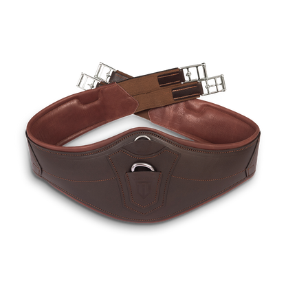 Gekreuzt liegender, anatomischer Winderen Pressure-Relief-Springgurt aus braunem Vollnarbenleder mit kleinem Bauchlatz. Die detailreiche Aufnahme zeigt die weiche, zweifarbige Lederpolsterung zur Druckentlastung für empfindliche Pferde, die robusten Elastikenden sowie den integrierten D-Ring für das Vorderzeug im Springparcours.