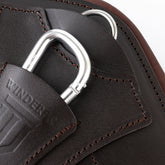 Nahaufnahme des halb versenkten Aluminium-Karabiners und D-Rings unter der Lederabdeckung mit geprägtem Winderen-Logo. Die Detailansicht zeigt die präzisen Nähte des braunen Vollnarbenleders zur hakenfreien Befestigung von Vorderzeug und Martingal.