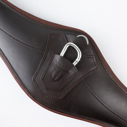 Zentralansicht des braunen Winderen Pressure-Relief Springgurts mit kleinem Bauchlatz. Die Aufnahme zeigt den anatomisch geformten Stoßschutz aus Vollnarbenleder mit halb versenktem Aluminium-Karabiner und zweifarbiger Polsterung für optimale Bewegungsfreiheit beim Springen ohne Stollen.