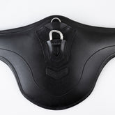 Nahaufnahme vom schwarzen Winderen-Pressure-Relief-Stollengurt aus Vollnarbenleder mit großem Bauchlatz. Zu sehen ist der halb versenkte Karabiner aus Aluminium unter der eleganten Lederabdeckung mit geprägtem Winderen-Logo zur sicheren Befestigung von Vorderzeugen sowie der darüber liegende halb versenkte, abgedeckte D-Ring für Hilfszügel wie ein Martingal.